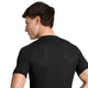 Der ses en person med kort, brunt hår set bagfra, iført en tætsiddende sort Saysky Mesh Base Layer T-shirt i unisex-udgave med struktureret overflade. Personens venstre arm er let bøjet, og hovedet er vendt mod venstre.