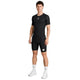 En mand står med ansigtet vendt fremad iført en tætsiddende sort Saysky Mesh Base Layer-T-shirt og sorte shorts med hvide mærkelogoer, hvide strømper og hvide sportssko, foran en ensfarvet hvid baggrund.