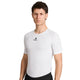 En mand med kort brunt hår har en tætsiddende hvid Saysky Mesh Base Layer T-shirt på, en letvægts-sportstrøje i mesh til både mænd og kvinder med et lille sort logo på brystet. Han står foran en ensfarvet hvid baggrund og vender sig let mod venstre.