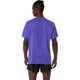 En person med mørk hud og en lille topknude ses bagfra iført en ASICS Metarun Ss Top, Herre, Cobalt Burst med ACTIBREEZE-teknologi og et struktureret, ventileret mønster, parret med sorte shorts.