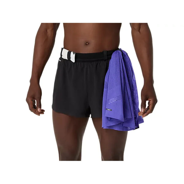 En person iført ASICS Metarun Split Short, Herre, Performance Black med et sort-hvidt bælte står med ansigtet fremad og holder lilla netstof over højre side af performance-løbeshortsene.