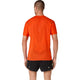 En mand står med ryggen til og er iført en orange Asics Metarun Ss Top, Herre, Cherry Tomato – en løbe-T-shirt til mænd med netlignende ACTIBREEZE-mønstre på ryggen – samt sorte løbeshorts, foran en ensfarvet hvid baggrund.