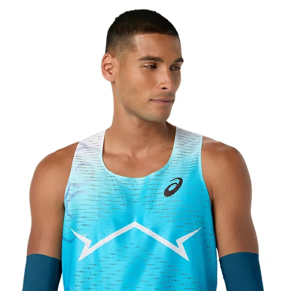 En mand med kort, mørkt hår har Asics Metaspeed Singlet, Herre i farven »Aquarium« på – en blå løbesinglet med et hvidt zigzagmønster og Asics-logoet – mens han står foran en ensfarvet hvid baggrund og kigger let mod venstre.