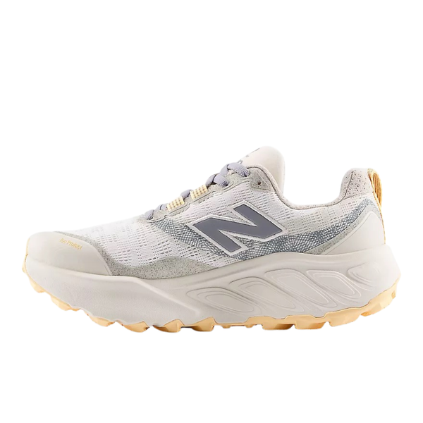 Sæt skub i dit trailgame med New Balance FreshFoam Hierro V9 Dame i Sea Salt/White Peach - hvid og lysegrå med et gråt N-logo, gule detaljer på hæl og sål og en struktureret ydersål, der giver ekstra greb.