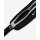 Et nærbillede af Nike Slim Waistpack 4.0 i sort/sort/sølv, unisex-design, viser en grå lynlås, et hvidt Nike-swoosh-logo og en sort rem med et andet swoosh - perfekt til at bære de vigtigste ting som en slim waistpack eller løb taske.