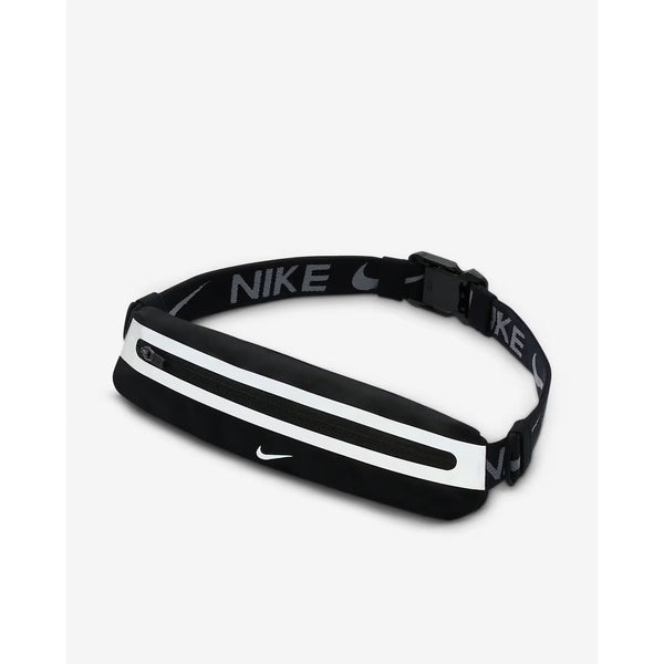 Nike Slim Waistpack 4.0 (Unisex) i sort/sort/sølv har hvid lynlås, refleksstribe og logo. Den justerbare rem viser Nike-navnet og swoosh i hvidt, hvilket gør den til en ideel waistpack for alle. Vist på en almindelig hvid baggrund.
