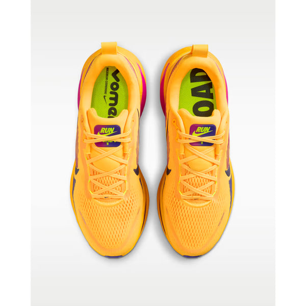 Et par Nike Vomero 18 løbesko herre i Citron Pulse/Blue Void-Laser Orange med gule snørebånd, lilla detaljer og neongrønne indersåler med fed "ROAD"- og "VOMERO"-tekst. Designet til komfort og stabilitet. Set ovenfra på hvid baggrund.