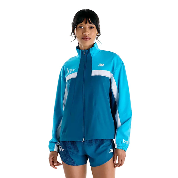 En person iført en blå og turkis New Balance NYC Marathon-jakke, Dame, Streamsong-træningsjakke med lynlås og matchende sportsshorts.