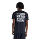 En mand står med ryggen til kameraet og har en sort New Balance NYC Marathon RC Essential Graphic T-shirt til mænd på. På ryggen er der trykt en markant hvid tekst, der lyder: »ITS THAT NEW YORK ENERGY let new york city motivate«. Denne løbetrøje, der er designet til byen, er fremstillet med NB ICEx-teknologi for optimal komfort og kombineres med sorte shorts. Han har kort, krøllet hår, hvilket fuldender et energisk look inspireret af New York City.