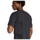 En person i en struktureret, kortærmet sort skjorte bærer en lille sort crossbody-taske og vender sig om på siden, så den ligner New Balance Athletics Reflective Packable Jacket for Men in Black set bagfra.