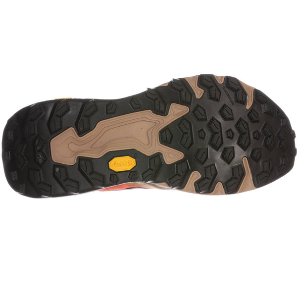 Nærbillede af New Balance Freshfoam Hierro V9 Dame i Desert Clay, der viser en sort Vibram Megagrip ydersål i gummi med multidirektionelle knopper for greb og et gult Vibram-logo i midten.