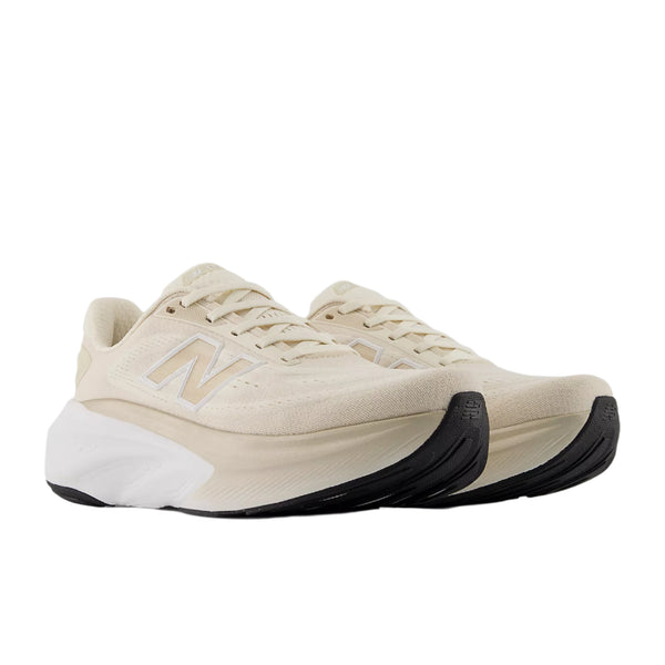 Et par beige New Balance Freshfoam More V6 Dame Permafrost-sneakers med hvide mellemsåler og sorte ydersåler vises på en hvid baggrund. Det ikoniske N-logo vises på siderne for maksimal komfort.