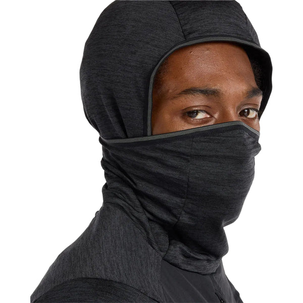 En mand bærer en sort New Balance Heat Grid Balaclava Hoodie med NB HEAT-teknologi og et indbygget ansigtsdække, der skjuler underansigtet, så kun øjnene og en del af panden er synlige.