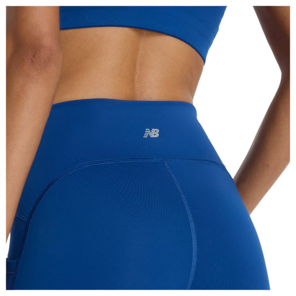 En person iført kongeblå sports-bh og New Balance Sleeck Pocket High Rise Tights, Dame, Galaxy Blue-svedtransporterende tights med en stilfuld linning, perfekt til enhver træningstights-dame, der prioriterer komfort.