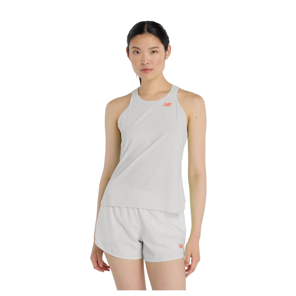 En person står med ansigtet fremad og er iført New Balance Race Day Ultra Light Singlet til kvinder i Grey Matter med et lille rødt logo og matchende shorts på en almindelig hvid baggrund.