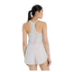 En kvinde med langt mørkt hår i hestehale ses bagfra iført New Balance Race Day Ultra Light Singlet, Dame, Grey Matter på en almindelig hvid baggrund.