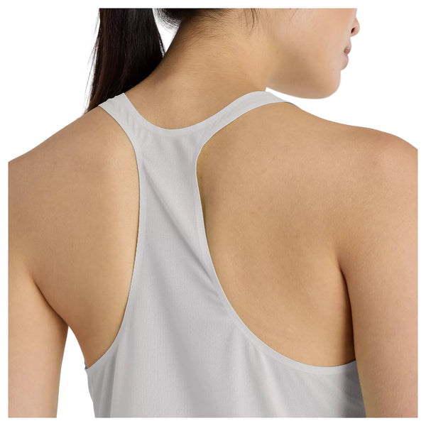 Et nærbillede viser en kvindes øverste del af ryggen iført New Balance Race Day Ultra Light Singlet, Dame, i Grey Matter - lavet af svedtransporterende materiale. Hun har langt, mørkt hår, der er trukket til den ene side.