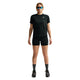 En kvinde kigger fremad i Nike ACG High-Waisted 4" Running Shorts, Dame, Black/Summit White, sammen med en sort t-shirt, grå sokker, sorte sportssko og blå solbriller. Baggrunden er helt hvid.