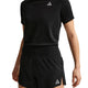 En person er iført sorte Nike ACG Mid-Rise Brief-Lined Running Shorts til kvinder og en matchende sort kortærmet skjorte, begge med et lille hvidt trekantet logo på venstre side. Personens hoved er ikke synligt på billedet.