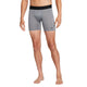 En person står barfodet med front mod en hvid baggrund iført Nike Dri-FIT Fitness Shorts til mænd i Smoke Grey/Black.