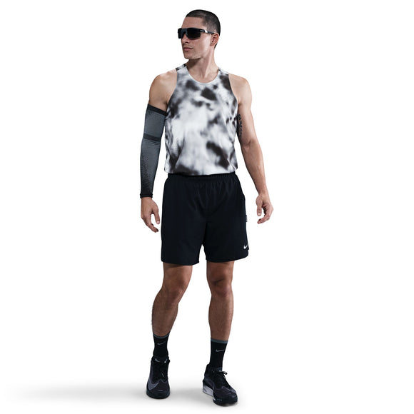 En mand står på en almindelig hvid baggrund iført solbriller, sorte shorts, sorte sneakers, sorte sokker, et sort kompressionsærme på højre arm og en Nike Dri-FIT ADV Running Tank Top til mænd i Black/Black/Reflective Silver.