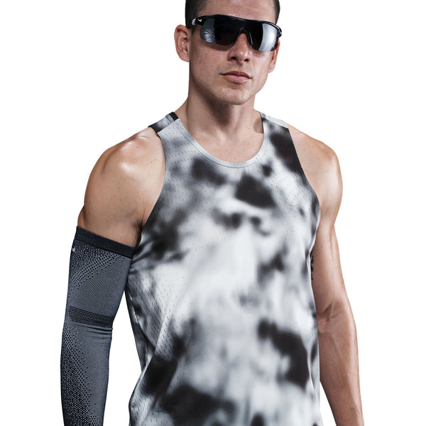 En mand i Nike Dri-FIT ADV Running Tank Top til mænd, Black/Black/Reflective Silver, med mørke solbriller og et sort kompressionsærme på højre arm, står på en hvid baggrund.
