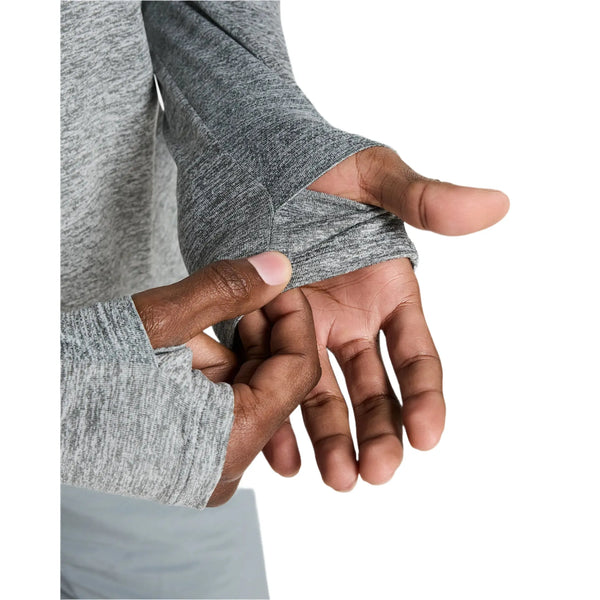 En person justerer tommelfingerhullet på en Smoke Grey Stride Half Zip Midlayer Running Top fra Nike. Det bløde, strækbare og åndbare stof er kun vist på overkroppen og hænderne mod en hvid baggrund.