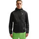 En mand i Nike ACG Trailwind Running Jacket (Anthracite/Summit White) står på en almindelig hvid baggrund iført limegrønne shorts.