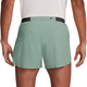 En person ses bagfra iført en hvid skjorte og Nike AeroSwift 4" Running Shorts, Herre, Steam/Black, som har en sort linning og en lille lynlåslomme til de vigtigste ting.