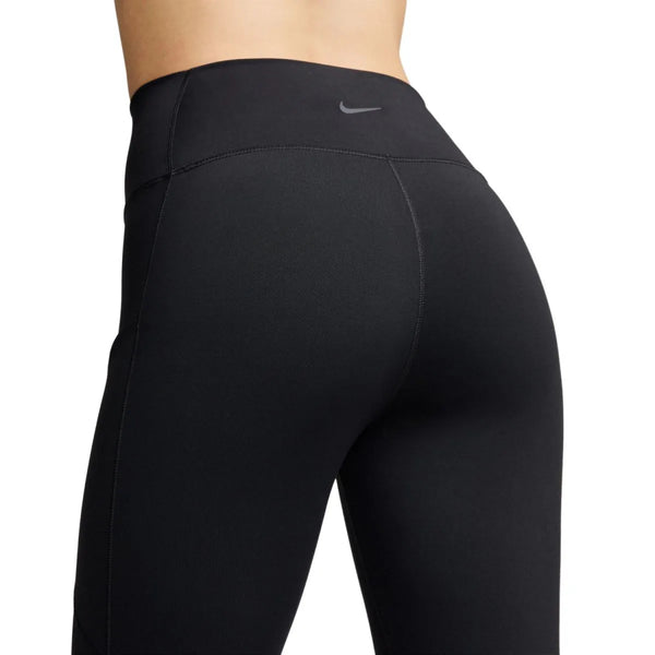 Et nærbillede af en person, der har Nike One High-Waisted 7/8 Dame-tights i farven Black/Black på, med Dri-FIT-teknologi og et lille Nike Swoosh-logo på bagside af linningen mod en ensfarvet hvid baggrund.