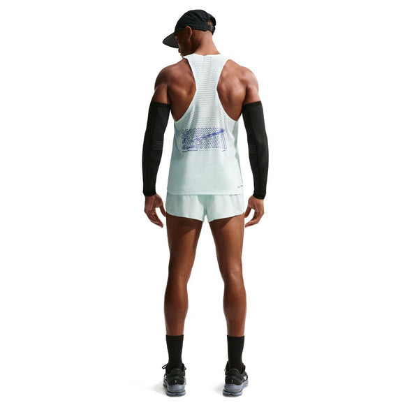En person står med ryggen til og er iført Nike Nk Dfadv Aeroswift Gfx Snglt, Herre i Barely Green/Lapis med hvide shorts, sorte ærmer, sort kasket og sokker samt løbesko på en almindelig hvid baggrund.
