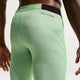 Nærbillede af en person iført Nike AeroSwift Running Half Tights, Herre, i Lime Blast/Steam/Light Silver/Black med Dri-FIT ADV-tekst nær linningen. Kun lænden, lårene og en del af den ene arm er synlige.