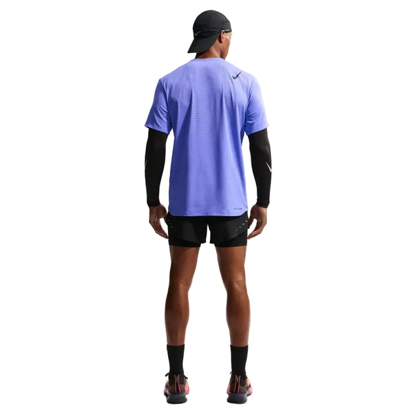 En person kigger væk og er iført en Nike Nk Dfadv Aroswft Ss Top, Herre i Sapphire/Black, sammen med sort kasket, ærmer, shorts, sokker og sportssko med pink såler på en almindelig hvid baggrund.