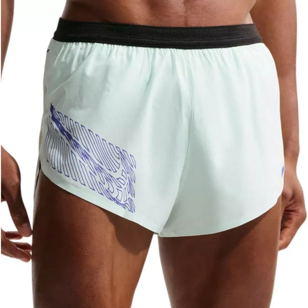 En person ses fra midterste del til øverste del af lårene iført Nike Nk Dfadv Arswft Gfx 2Bf Shrt til mænd i Barely Green/Lapis med Dri-FIT ADV-teknologi, en sort linning og et blåt abstrakt design på venstre side.