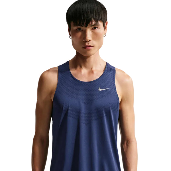 En person med kort sort hår har en Nike Nk Dfadv Stride Tank til herre på i farven Midnight Navy/Reflective Silv, med hvidt Nike-logo på venstre bryst. Baggrunden er helt hvid.