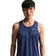 En person med kort sort hår har en Nike Nk Dfadv Stride Tank til herre på i farven Midnight Navy/Reflective Silv, med hvidt Nike-logo på venstre bryst. Baggrunden er helt hvid.
