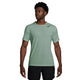En mand iført en lysegrøn Nike Nk Dfadv Aroswft Ss Top, Herre, Steam/Black og sorte shorts står let vendt mod en almindelig hvid baggrund og fremviser sit ultraløbræning-look.