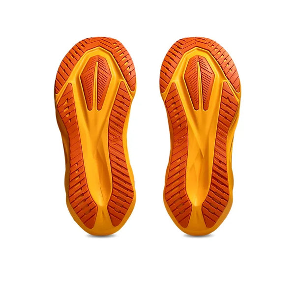 Et par atletiske skosåler set nedefra med en lysegul base og orange slidbane, der fremhæver Asics Novablast 5, Herre, Yamabuki/Anzu's ekstra stødabsorbering fra FF BLAST MAX-skum på en hvid baggrund.