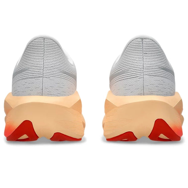 Et par hvide ASICS Novablast 6 Dame-løbesko i farvekombinationen White/Vivid Coral set bagfra, med tykke beige såler med røde detaljer på undersiden og en overdel i struktureret strik, der er designet til at give energiretur ved hvert skridt.
