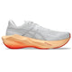 Asics Novablast 6 Dame i hvid/Vivid Coral er en hvid sportsløbesko med en tyk, formet mellemsole i fersken-orange og en levende rød ydersål, med minimalt mærke og en åndbar overdel i mesh med snørebånd – inspireret af den energiretur-teknologi, der findes i modeller som ASICS Novablast 6.