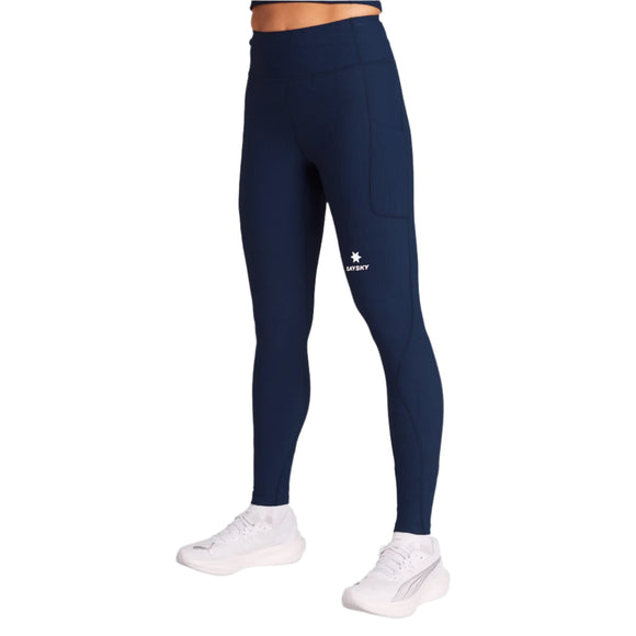 En person er iført Saysky W Combat+ Rib Long Tights til kvinder i blå, med et lille hvidt logo på venstre lår og sammen med hvide sneakers. Overkroppen er ikke synlig. Ideelle løbetights dame til din næste løbetur eller træningssession.