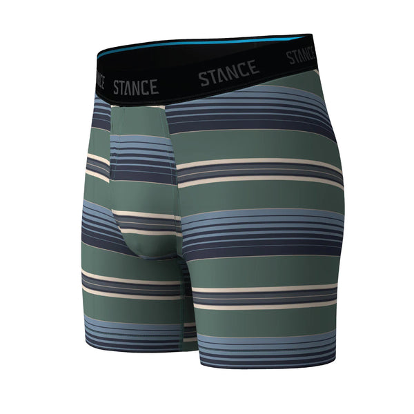 Stance Otis Wholester herreboxershorts med grønne, blå, grå og beige vandrette striber. Den sorte linning er prydet med STANCE-logoet i hvide bogstaver. Disse boxershorts er fremstillet af glat og elastisk Butter Blend-stof, der sikrer både komfort og Wholester-støtte.