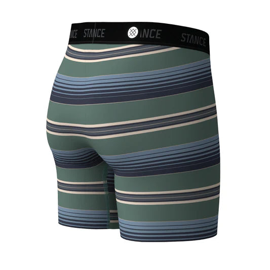 Et par Stance Otis Wholester herre-boxershorts med vandrette grønne, blå og beige striber. Den sorte linning er forsynet med teksten »STANCE« og mærkets logo i hvidt. Fremstillet af Stances karakteristiske Butter Blend-stof til boxershorts, der sikrer enestående blødhed og Wholester-støtte. Billedet er taget bagfra.