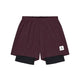 Et par Pace 2-i-1-shorts i størrelse 5″ til mænd i bordeauxrød fra Saysky, med indbyggede sorte kompressionsshorts indeni, vist på en hvid baggrund. Et lille hvidt mærke med en sort stjerne og tekst pryder den nederste venstre kant foran, hvilket gør disse shorts ideelle til sportsaktiviteter.