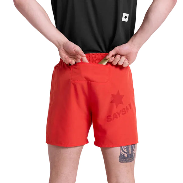 En person iført sort skjorte og Saysky Pace Shorts 5", Herre, Red ses bagfra, mens han åbner en lille lomme i linningen på performance-shortsene. En tatovering er synlig på venstre lår.