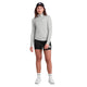 En person står med ansigtet fremad i en sort kasket, Saysky Pace 1/2 Zip Long Sleeve, Dame, Grey top, sorte shorts, hvide sokker og hvide sneakers - perfekt til træning eller løb. Baggrunden er almindelig hvid.