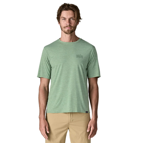 En mand med lysebrunt hår og skæg står med ansigtet fremad og er iført en Patagonia Cap Cool Daily Graphic Shirt, Herre, i Strataspire/Ellwood Green X-Dye. Baggrunden er almindelig hvid.