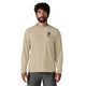 En mand med kort krøllet hår og skæg er iført Patagonia L/S Cap Cool Daily Graphic Shirt til mænd i Earlylines/Pumice X-Dye, fremstillet af genbrugspolyester, med en lille farverig brystgrafik og mørkegrå bukser på en hvid baggrund.
