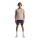 En mand ser frem for sig iført en On Performance-T til mænd i Desert/Cinder, marineblå shorts, hvide strømper og hvide løbesko, mens han står på en almindelig hvid baggrund.