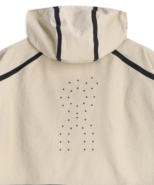 Her præsenterer vi ON Performance Volt Jacket, Herre, Hare: Denne beige, ultralette løbejakke har en sammenpakkelig hætte, der er praktisk i skiftende vejr. Karakteristiske sorte striber og et gittermønster af små sorte prikker pryder ryggen, mens den let strukturerede overflade giver stoffet et unikt udseende og en unik fornemmelse.